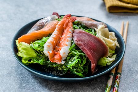 Sashimi Salad with Wakame, Seaweed, Salmon, Sea Bass, Shrimp, Kani, Mackerel Fish, Tuna served with Chopsticks. Traditional Organic Food.の写真素材