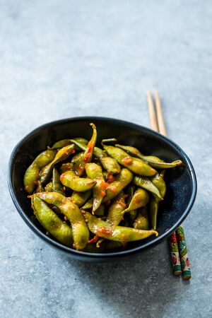 Spicy Sambal Edamame with Chopsticks / Spiced Style with Red Hot Chili Sauce. Traditional Organic Food.の写真素材