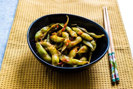Spicy Sambal Edamame with Chopsticks / Spiced Style with Red Hot Chili Sauce. Traditional Organic Food.の写真素材