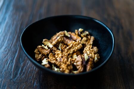 Walnut Kernels and Whole walnuts in Porcelain Bowl.  Organic Food.の写真素材