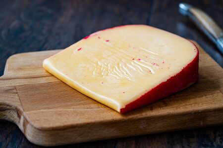 Hard Dutch Gouda Cheese, Close-up on Wooden Board with Knife. Organic Traditioal Food.の写真素材