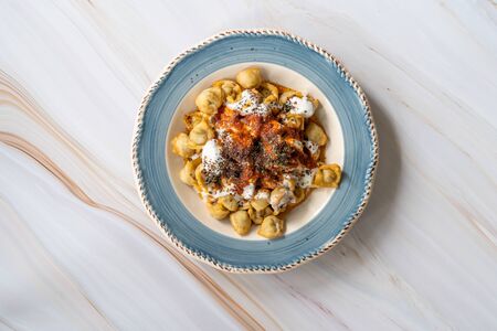 Homemade Russian Pelmeni Fried Dumplings with Meat, Yogurt, Tomato Sauce and Spices. Traditional Healthy Food.の写真素材