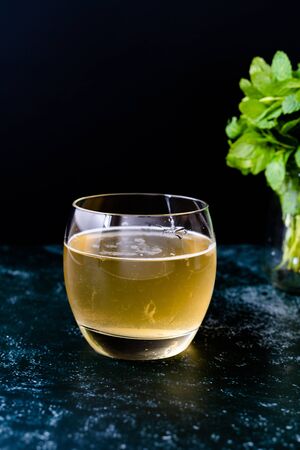 Homemade Traditional Healthy Fermented Raw Kombucha Tea with Mint Leaves in Glass Ready to Drink....