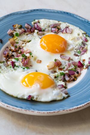 Sunny Side Up Fried Eggs with Red Onions and Chives for Breakfast in Plate. Organic Food.の写真素材