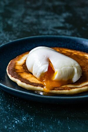 Poached Egg with Pancake in Plate for Breakfast. Healthy Organic Food.
