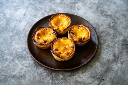 Pasteis de Nata or Belem Tart. Portuguese Custard made with Egg, Cinnamon, Sugar and Flour on Wooden...