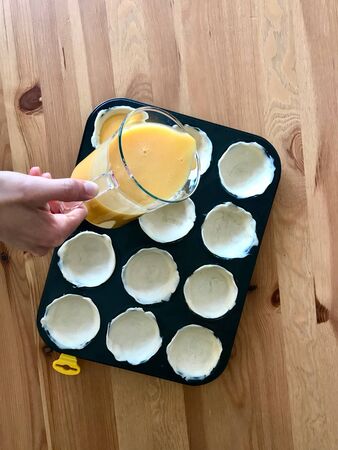 Making and Cooking Pasteis de Nata or Belem Tart. Portuguese Custard made with Egg, Cinnamon, Sugar...