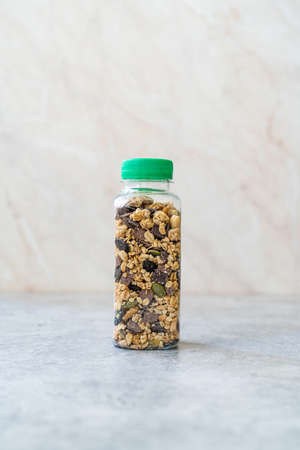 Roasted Granola in Plastic Bottle with Pumpkin Seeds, Chocolate Drops and Honey. Ready to Eat.の写真素材