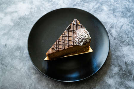 Raw Chocolate Cake with Cashew and Flavored with Date Fruit for Paleo Diet. Healthy Organic Dessert with No Sugar Free and Gluten Free in Black Plate. Ready to Serve and Eat.の写真素材