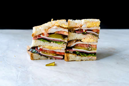 Classic Club Sandwich on Marble Surface. Includes Ham, Cheese, Lettuce, Tomato Slices. Light background. Close-up. Ready to Eat.の写真素材