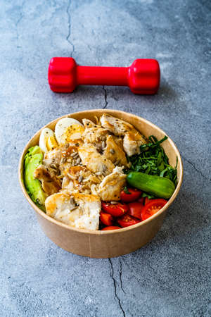 Healthy Protein Fitness Food Chicken, Egg, Spinach, Avocado and Cucumber with Fitness Equipment...