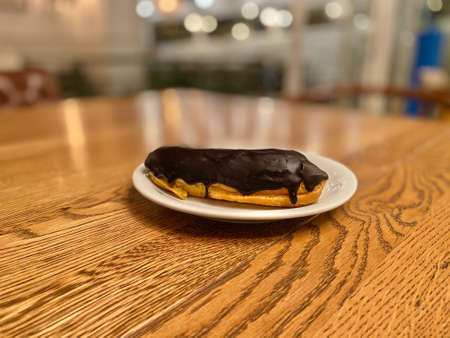 Chocolate Eclair served in Plate at Restaurant Wooden Surface Table. Ready to Eat.