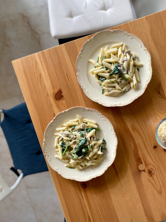 Penne Pasta with Baby Spinach and Truffle Cream Sauce. Served with Parmesan Cheese. Ready to Eat with Chair.の写真素材