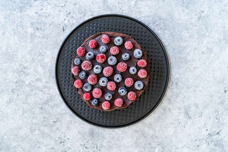 Gluten Free Vegan Chocolate Raw Cake with Raspberries and Blueberries. Ready to Eat.