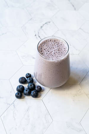 Homemade Smoothie with Fresh Blueberries on Marble Surface. Ready to Drink.