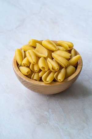 Homemade Dry Organic Raw Cavatelli Pasta in Wooden Bowl. Ready to Cook.