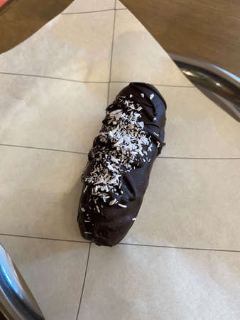 Homemade Bitter Chocolate Covered Coconut Bar served with Plate at Restaurant. Organic Snack.
