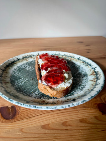 Homemade Pomegranate jam with cream cheese on bread served at breakfast. Organic Healthy foodの写真素材