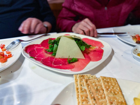 Beef carpaccio with arugula, parmesan cheese. Served at restaurant.の写真素材