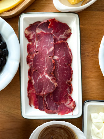 Pastirma Dried Pastrami slices, beef meat with herbs on wooden board. Wooden background. top view Ready to eatの写真素材