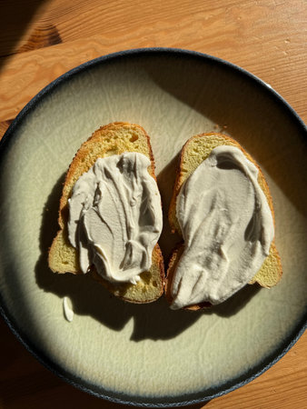 Homemade Cashew cream on bread served with plate on wooden tableの写真素材