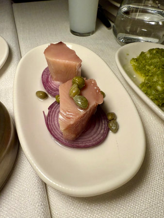 Turkish appetizer Lakerda with capers tuna, lemons and a red onion served at restaurant