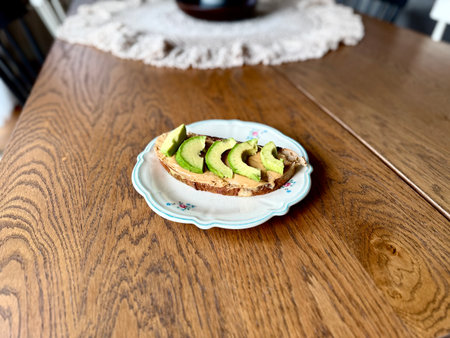 Avocado and peanut butter toast in plate on wooden table. Ready to eat