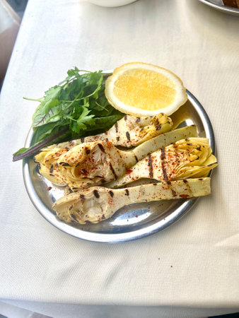 Grilled artichoke served with olive oil and herbsの写真素材