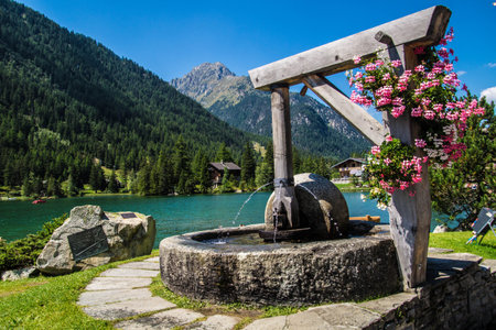 Old well on the shore of the lake in the Austrian Alps.の写真素材