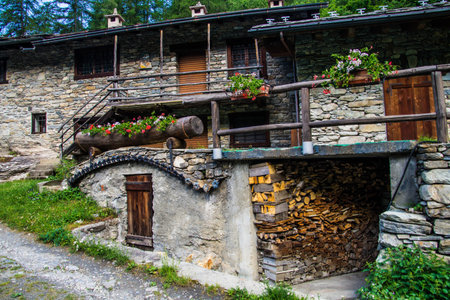 Old stone house with firewood in the village of Hochgau, Switzerlandの写真素材