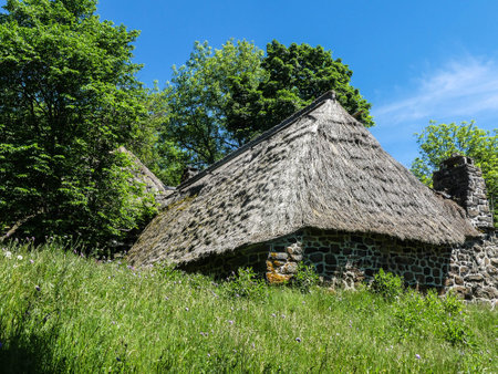 Old stone house with thatched roof in the countryside of the Czech Republicの写真素材