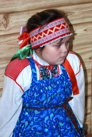 russian girl in traditional clothes in russian house (izba)の写真素材