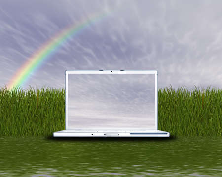 laptop computer on the green grass and blue skyの写真素材