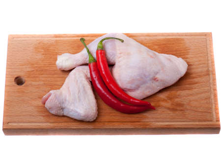 uncooked chicken on a wooden cutting boardの写真素材