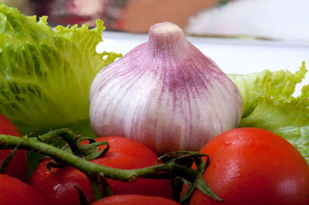 tomato and salad on a wooden cutting boardの写真素材
