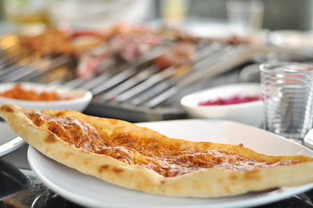 Traditional Cypriot meze and mix meat and chicken kebab table with charcoal barbecue on the table...