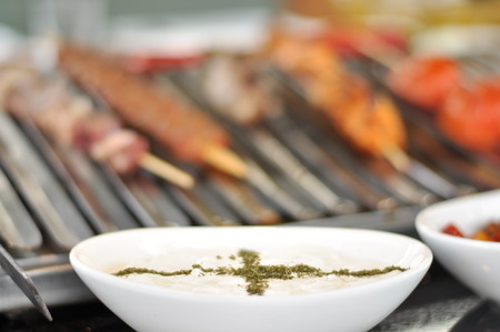 Traditional Cypriot meze and mix meat and chicken kebab table with charcoal barbecue on the table for self cooking during the eating timeの写真素材