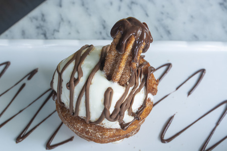 Churros Icecream on white plate with chocolate sauce with yellow backgroundの写真素材