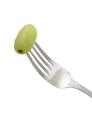 A fork with a grape on it to show healthy eating.の写真素材