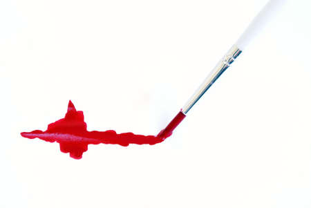 A paint brush making a red stroke of paint.の写真素材