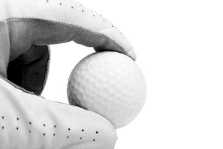A golfer's hand pinches the ball over white.の写真素材