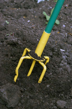 A closeup shot of a hand tiller working the dirt around.の写真素材