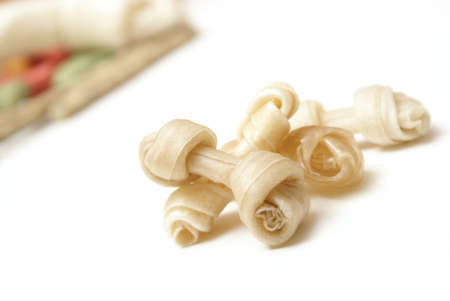 A pile of small rawhide bones infront of a bunch of other treats.の写真素材