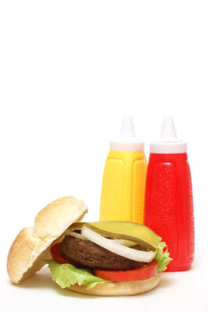 An isolated hamburger with mustard and ketchup bottles.の写真素材