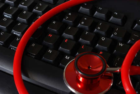 A stethoscope on a keyboard with arranged letters that spell out the word help.の写真素材
