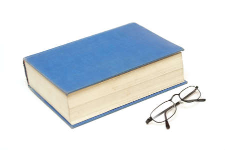 A large book alongside a pair of reading glasses for the educated mind.の写真素材