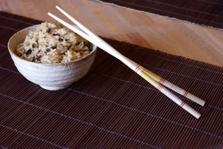 A freshly cooked bowl of rice with wooden chopsticks to enjoy a taste of the orient.の写真素材