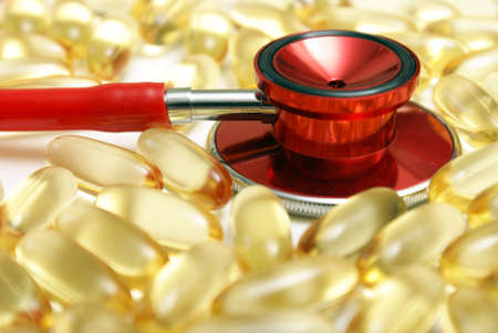 A macro shot of a stethoscope and Omega-3 supplements to address the benefits of their intake for a healthy heart.の写真素材
