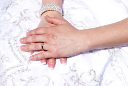 A closeup shot of a brides hands on her wedding dress.の写真素材