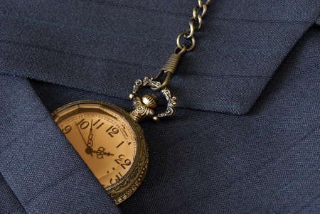 A macro shot of a business mans suit while checking the time on his pocket watch.の写真素材
